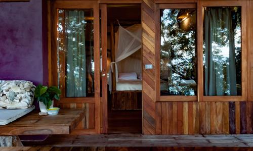 a room with a bench and a room with a bedroom at BOA BOA Bacalar in Bacalar