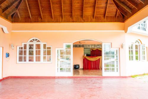 an open door of a house with a red curtain at Shields Negril Villas in Negril