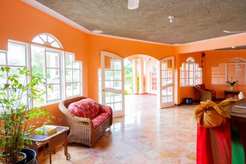 a living room with orange walls and a chair at Shields Negril Villas in Negril