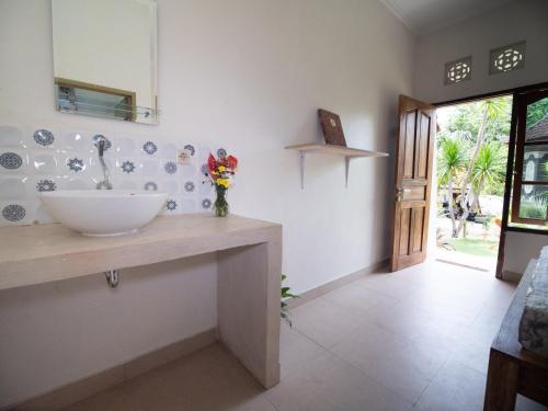 Un baño con un lavabo y un espejo en la pared. en Villa Ricca Eco Lodge, en Uluwatu