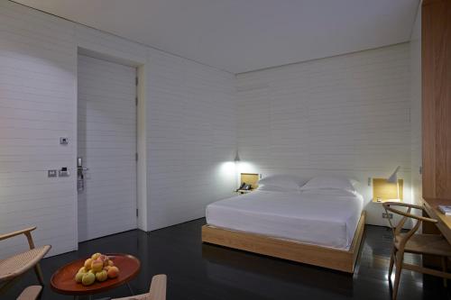 a bedroom with a bed and a table with a bowl of fruit at Atrio in Cáceres