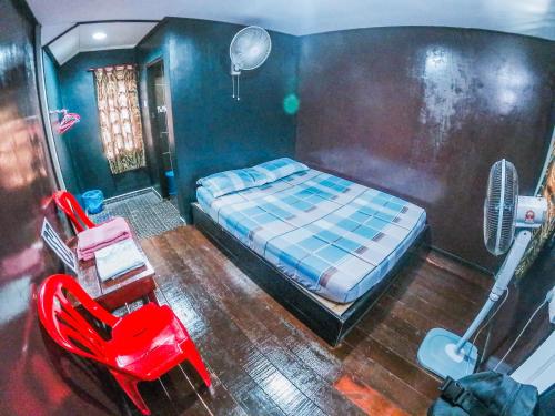 1 dormitorio con 1 cama, escritorio y ventilador en Maznah Guest House, en Cherating