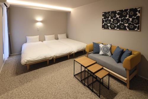a hotel room with two beds and a couch at Koti Sopo Universal Bay 2 by Liaison in Osaka