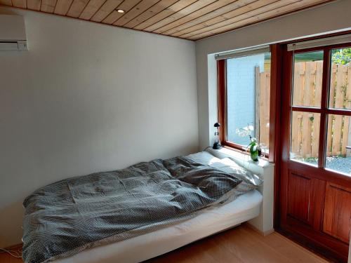 1 dormitorio con cama y ventana en Hedegaard Anneks Skærbæk, en Herning