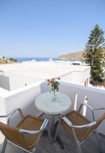 a table and chairs on a balcony with a view of the ocean at Studios Akrogiali in Aegiali