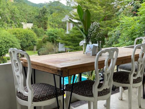 a wooden table with four chairs around it at Pai Vieng Fah Resort in Pai