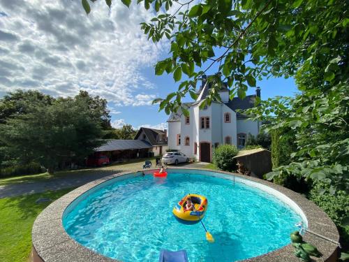 a person in a paddle boat in a swimming pool at Villa Maxenstein in Wolkenstein