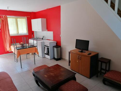 a living room with red walls and a small kitchen at Le sacré cœur bis -duplex 5pl in Le Havre