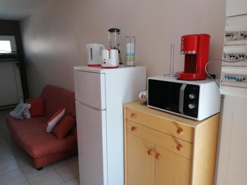 una cucina con un forno a microonde sopra un frigorifero di Le sacré cœur bis -duplex 5pl a Le Havre