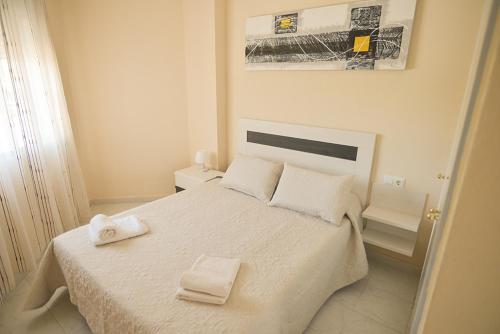 トレビエハにあるLow Cost Marinaのベッドルーム1室(白いベッド1台、タオル2枚付)