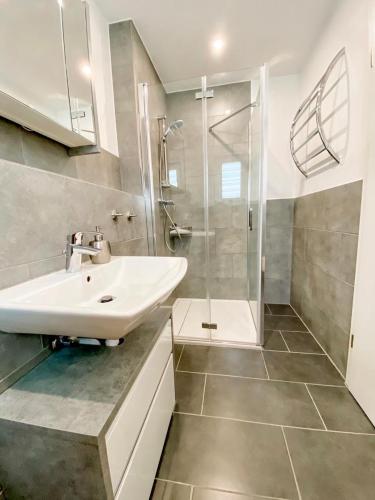 a white bathroom with a sink and a shower at Ferienwohnung Bodensee Nenzingen Hegau in Orsingen-Nenzingen