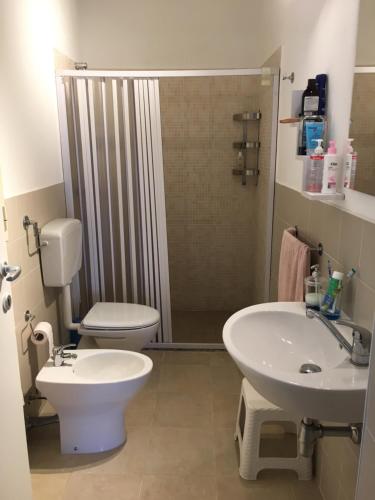 a bathroom with a toilet and a sink and a shower at Villetta Gaia in Marina di Ragusa