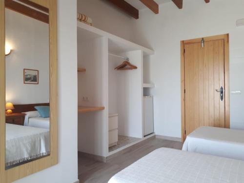 a bedroom with two beds and a mirror at Hostal Marblau Ibiza in Ibiza Town