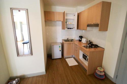 a small kitchen with wooden cabinets and a window at Baan Rub Lom by Jane in Pak Chong
