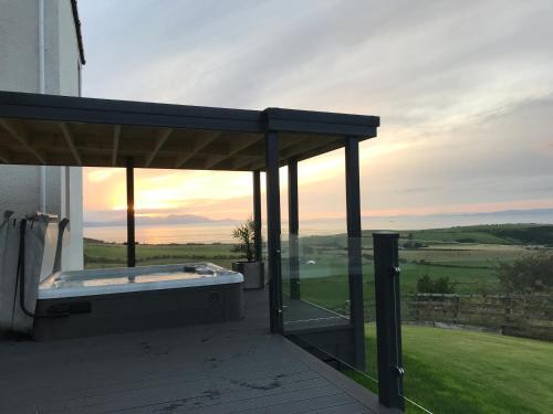 a hot tub under a pavilion on a house at Carrick Hills Cosy Croft STL SA-00137-F in Dunure