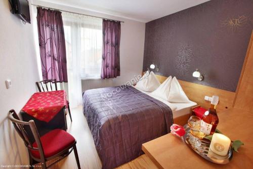 a hotel room with a bed and a table at Ubytovanie pod Tatrami in Nová Lesná