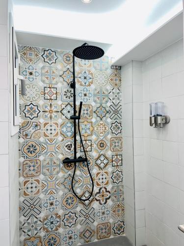 a bathroom with a shower with a tiled wall at Seafront New Apartment Boutique in Lloret de Mar