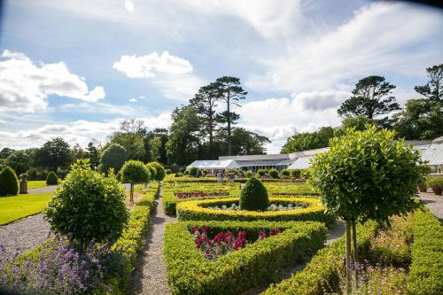 a garden with flowers and hedges and a building at The Beeches in Killarney