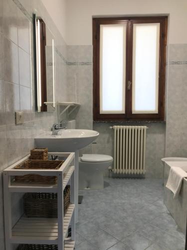 a white bathroom with a sink and a toilet at Residenza Margherita in Tremezzo