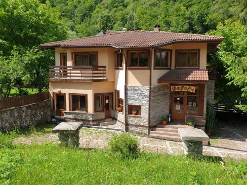 a small house with a porch and a balcony at Family Hotel Fedora in Ribarica