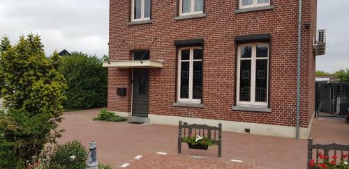 a brick building with a bench in front of it at ANNO 1919 in Swalmen