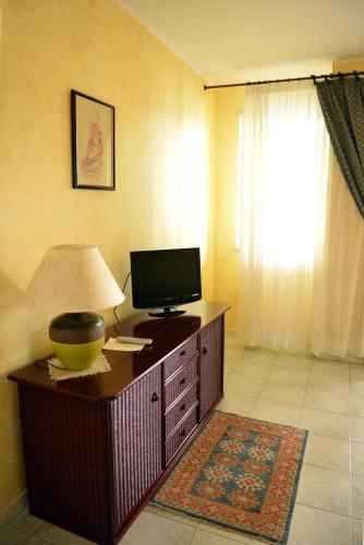 a room with a desk with a television and a lamp at Hotel Blue Rose's in Mesagne