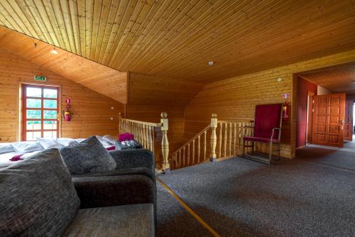 a living room with a couch and a wooden ceiling at Saules sēta in Lazdenieki