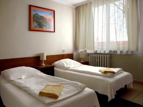 a hotel room with two beds and a window at Hotel Turystyczny in Białystok