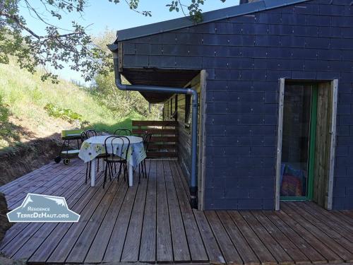 a wooden deck with a table and chairs on it at Résidence Terre de Haut in Super Besse
