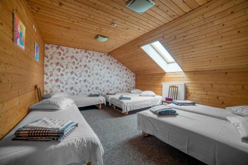 a room with three beds in a wooden room at Saules sēta 