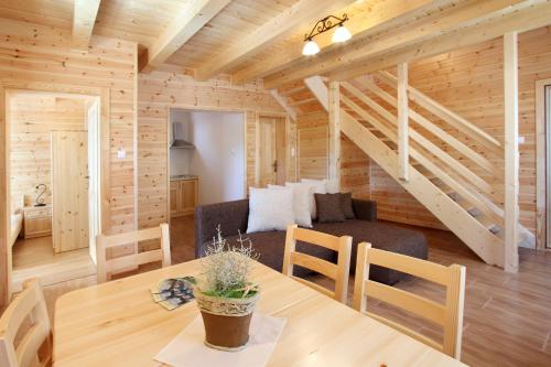 uma sala de jantar e sala de estar num chalé de madeira em Family Panzio es Apartman Hazak em Lipót