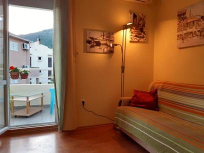 een kamer met een bed, een lamp en een raam bij One-bedroom mediterranean flat near the sea in Petrovac na Moru