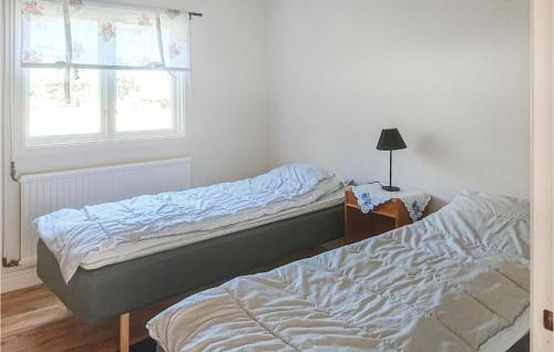 1 dormitorio con 2 camas y ventana en Lovely Home In Valdemarsvik With Lake View, en Valdemarsvik