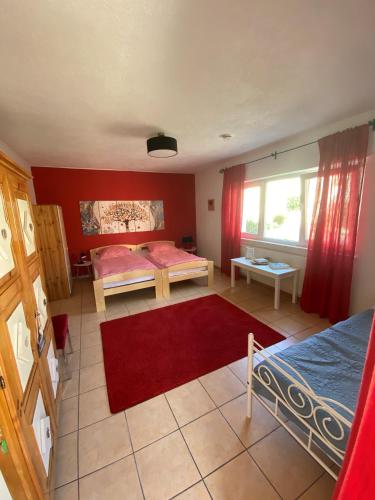 a bedroom with two beds and a red wall at Ferien- und Monteurswohnung Heilbrunnen in Wörth am Rhein