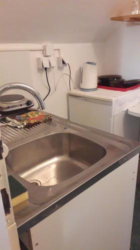 una encimera de cocina con fregadero en una cocina en Hostel Bata, en Kanjiža