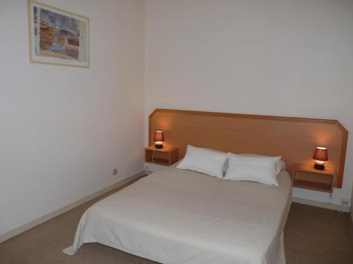 1 dormitorio con 1 cama blanca y 2 lámparas en 2 mesas en Sphinx Résidences - Tempologis Mémorial, en Caen