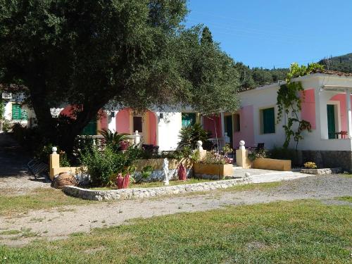 a house with pink and white houses and a tree at Vanilla House Paleokastritsa in Paleokastritsa