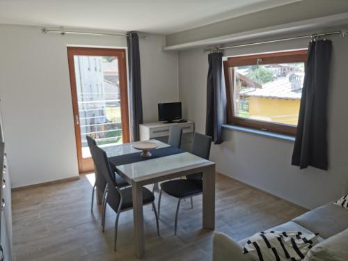 a living room with a table and chairs and a window at La Maison D' Amelie in Fenis