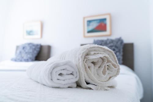 a pile of towels sitting on top of a bed at Casa Aguila Ibiza in Cala Vadella