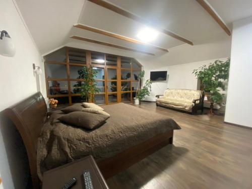 ein Schlafzimmer mit einem Bett und einem Sofa in einem Zimmer in der Unterkunft Kozak's Dream in Kamjanez-Podilskyj