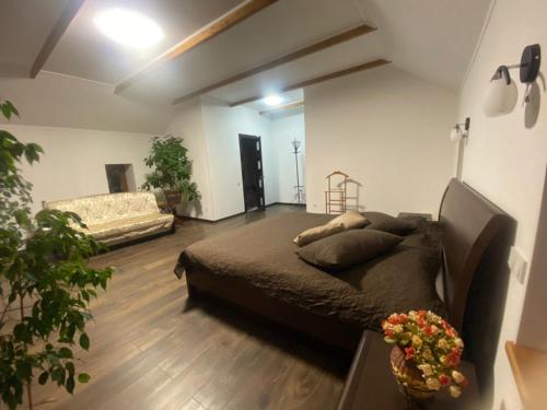 ein Schlafzimmer mit einem Bett und einem Sofa in einem Zimmer in der Unterkunft Kozak's Dream in Kamjanez-Podilskyj