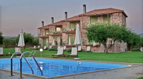 a house with a swimming pool in front of a building at Messinian Horizons in Marathopoli