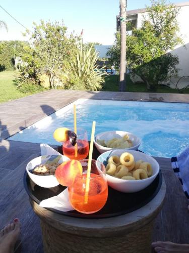 a tray of fruit on a table next to a swimming pool at Relais Dea Degli Ulivi in Agrigento