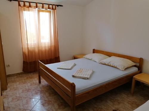 a bedroom with a bed and a window at Apartments Villa Venera in Ražanac
