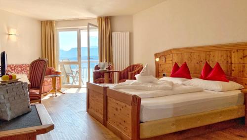 a bedroom with a large bed with red pillows at DAS BADL - Smart Retreat AO in Caldaro