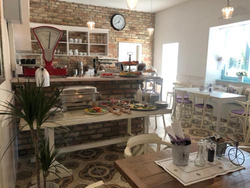 a kitchen with a table and chairs and a clock at Villa Bella in Badacsonytomaj