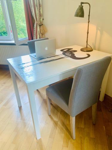 a white desk with a laptop and a chair at la Tour d'Héloïse - 10' de Bruxelles in La Hulpe