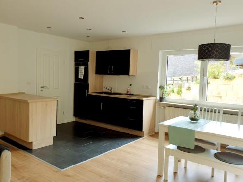 a kitchen with a black refrigerator and a table at Ferienwohnung im Green in Bad Neuenahr-Ahrweiler