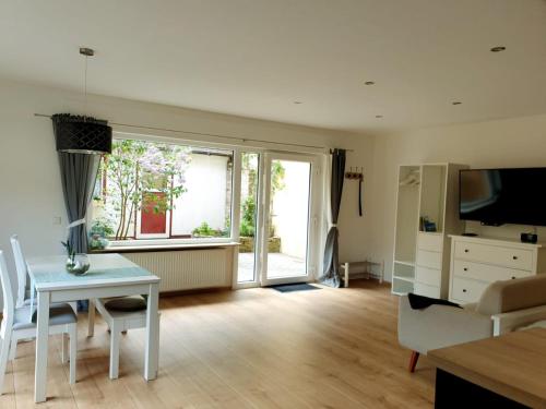 a living room with a table and a television at Ferienwohnung im Green in Bad Neuenahr-Ahrweiler