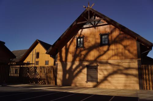 a large wooden building with a fence in front of it at Stenholmens Gårdshotell in Linköping